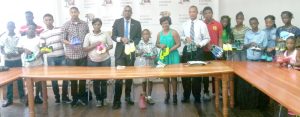 Director of Sports, Christopher Jones (centre) with We HOPE Inc President, Claudia John (on his left) and AAG President, Aubrey Hutson (on her left) among some of the athletes after they received the running shoes.