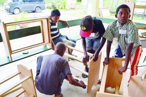 Boys working on shoe racks at the camp