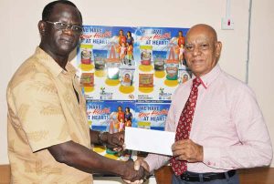 Marketing Consultant of NAMILCO, Affeeze Khan (right) hands over the sponsorship to Colin Boyce yesterday.