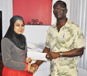 Office Manager at R&D Engineering Services Inc., Suraiya Sahid (left) makes their presentation to Colin Boyce yesterday at the 35 North Road Office of the Company.