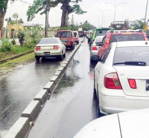 Vehicles illegally speeding along the area designated for pedestrians force their way ahead of the line. 