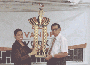 Justice Cecil Kennard receives the Feature race trophy yesterday from Maria Munroe, DDL's Brand Manager (Wines & Spirits).