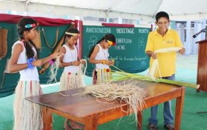 An Amerindian elder and children demonstrating Tibisiri plaiting.