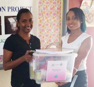 A YCG representative hands over a science kit to a teacher during a session of the inquiry-based scientific skills training.