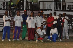 Floodlight skipper Patrick Khan (left) accepts the trophy from Nadir Baksh in the presence of his team mates. 