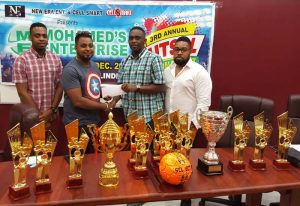 Aubrey Major Jnr. (right) collects the sponsorship from Chris Persaud of Cell Smart, while observing the moment are Sharif Major (left) and Kenrick Noel New Era Co-Directors.