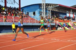 Alita Moore eases across the finish line yesterday afternoon after outclassing Natrena Hooper and Nikita Joseph in the Women’s 200m race. 