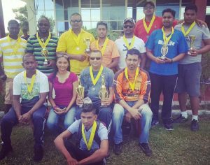 At right the winners pose with Joaan Deo: Standing from left, Ravi Jagdat (CIDI), Roland Fanfair (Digicel), Paul Parasram (Digicel), Rohan Mangal (Digicel), Trevor Parasram (CIDI), Bidesh Persaud (Digicel), Pradeep Baidjoe (CIDI), and Leon Sewnandan (CIDI). Sitting from left: Rajesh Singh (Auto), Joaan Deo, Ravin Balkaran (Auto), and Saeed Mohammed (Auto). In front is Kennard Singh of Auto.