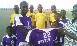 Buxton Stars U-17 Captain Kareem Wills is all smiles as he receives one of the uniform tops from Ms Avril Abrams on behalf of Ms June Griffith-Collison.