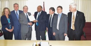  Minister of Natural Resources Raphael Trotman (centre) receives the letter of notification from Jeff Simons, Country Manager of ExxonMobil in the presence of representatives from Nexen Energy and Hess Corporation, at the Ministry’s Boardroom.