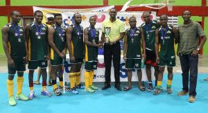 Director of Sport Christopher Jones hands over the winning trophy to Pepsi Hikers Captain Robert Frane in the presence of GTT representative Dexter Wyles (right) and teammates on Sunday.