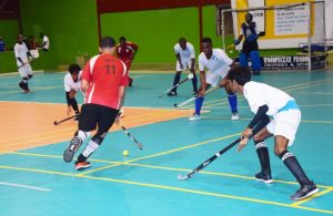 Old Fort’s Jason De Santos (backing camera) attempts to dribble past a host of Saints defenders during their encounter on Monday, at the National Gymnasium. 