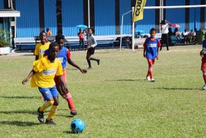 Players from St. Agnes and West Ruimveldt battle for possession of the ball during their semi-final encounter yesterday.