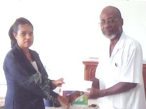 Ms. Silvia Wallerson (left) of China Trading hands over their donation recently to Organiser Lennox Arthur.