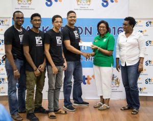 Participating members of V75 receiving their prize from Minister of Public Telecommunications Cathy Hughes (From Left) Asa Brouet, Ashim Badrie, Shemar Lindie, Eldon Marks, Minister Hughes and a GTT representative. 