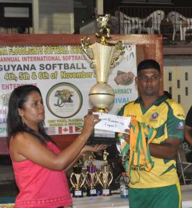 Regal open team Captain Fazal Rafiek collects the trophy and medals from a representative of the sponsors. (Zaheer Mohamed photo) 