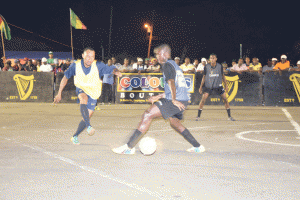 Broad Street Bullies Jimmy Gravesande (yellow bib) tries to go past a player from Camp Street All Stars during their encounter on Tuesday evening.