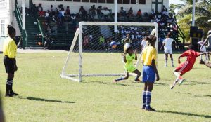 North Georgetown’s Alicia James (red uniform) scores in their clash against West Ruimveldt which ended in a 1-1 stalemate.