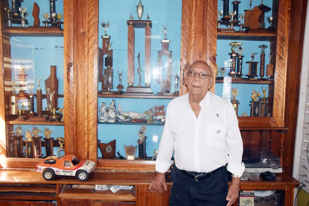 https://www.kaieteurnewsonline.com/images/2017/11/Pat-Holder-poses-at-one-of-his-trophy-cabinets-at-his-home-which-has-accolades-that-are-over-50-years-old.jpg