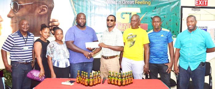 https://www.kaieteurnewsonline.com/images/2017/12/Den-Amstels-Coach-ONeal-Yearwood-receives-the-sponsor-cheque-from-GT-Beer-Brand-Manager-Jeoff-Clement-in-the-presence-of-other-club-officials-and-Banks-DIH-Managers-copy-2.jpg