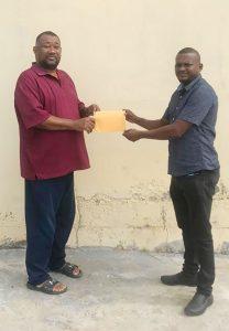 RL Contracting CEO Rondhall Lewis hands over sponsorship to BCB President Hilbert Foster.