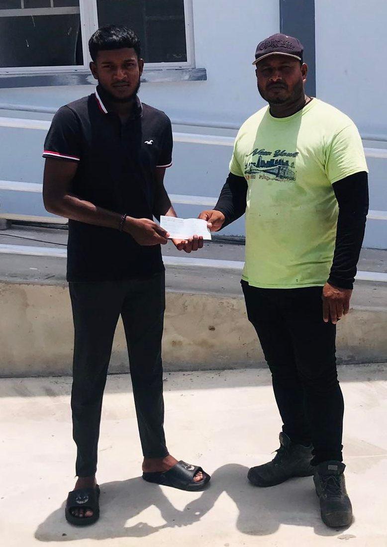 A representative of Armco Construction hands over the sponsorship to BCB PRO Jonathan Rampersaud.