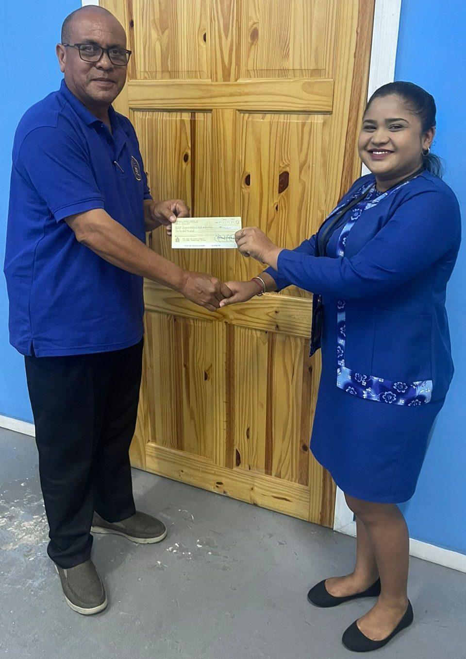 GuyanaNRAFullbore Vice Captain, Leo Ramalho receives the cheque from the Administrative Manager of Queensway Security Service Inc., Ms. Cindy Girwar. 