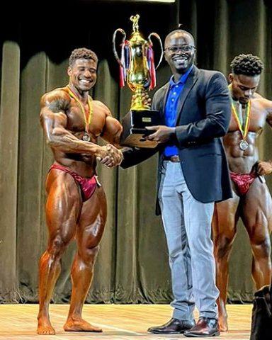 Flashback of Darious Ramsammy (left) receiving his Mr. Guyana trophy from GBBFF Head Keavon Bess.