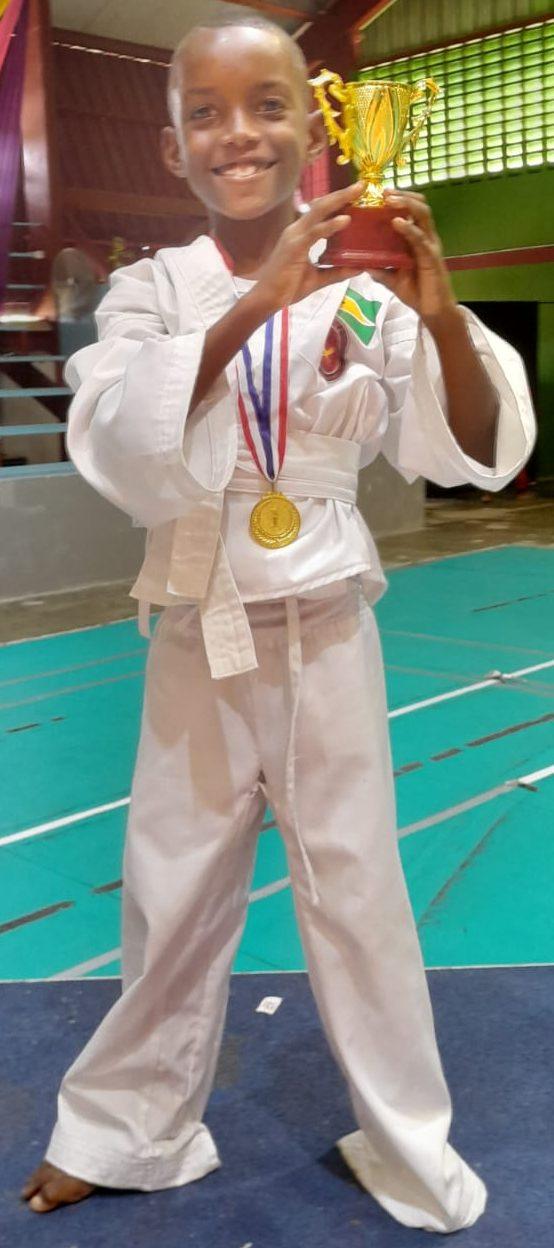 ACMA youngest Athlete, Kevin McLennan displaying his 1st place awards in Freestyle Kata and Traditional Kata.