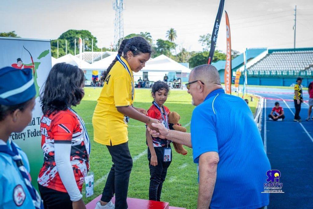 10 yr old Victoria Kum receiving her Gold medal from USA Archery Coach and Judge Phil Graves.