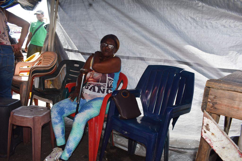 This grandmother trying to get to her home, had to seek refuge from the broiling sun, inside a roadside beverage stall.