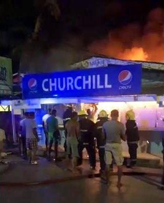 In this screen grab, firemen and members of the public attempt to extinguish a fire which gutted the Churchhill Supermarket at Timehri Base Road, East Bank Demerara on Wednesday morning.