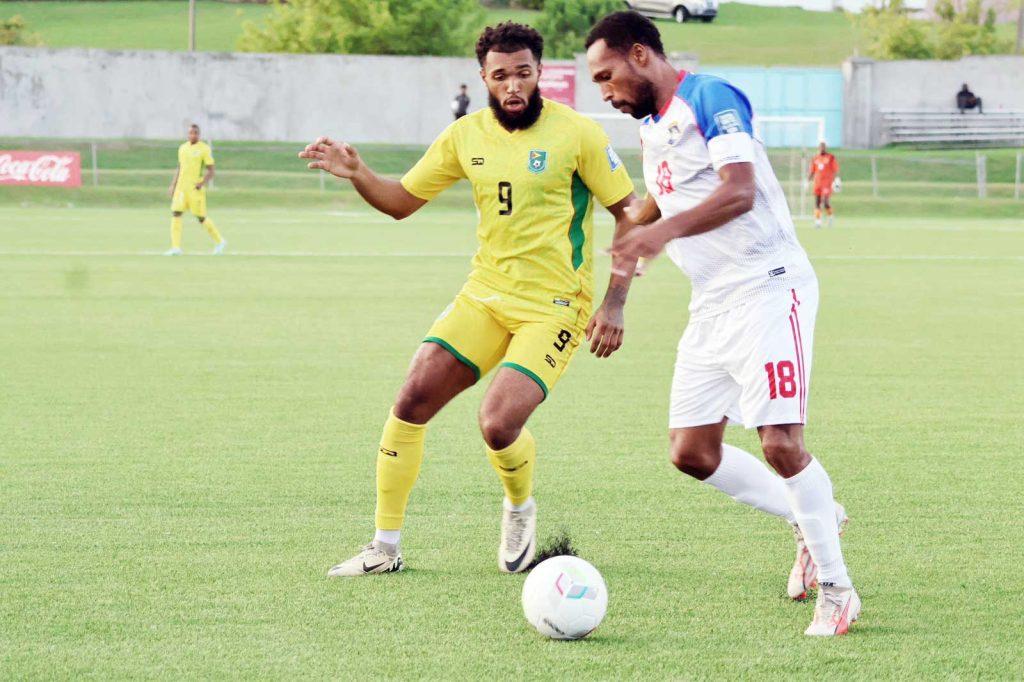 Deon Moore (#9) challenges Belize’s Everal Trap during Guyana’s 3-1 win in Barbados. (Jemima Holmes photo).