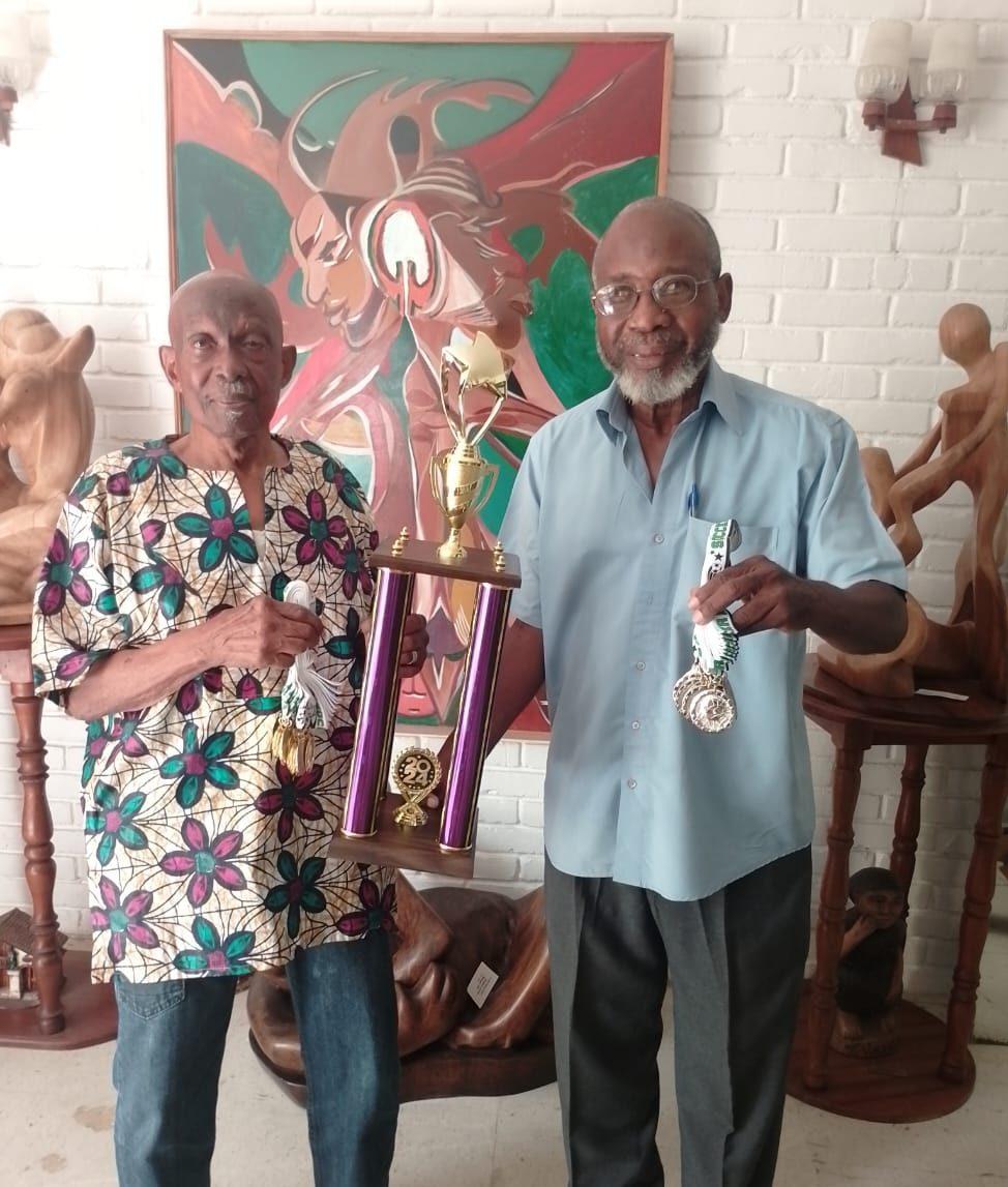 Ex-Mayor of Georgetown, Hamilton Green (left) and Tournament coordinator Lennox Arthur exhibiting the first-place trophy which was donated by former national footballer Patrick 'Labba' Barton.