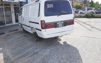 Minibus without wheels left in parking lot